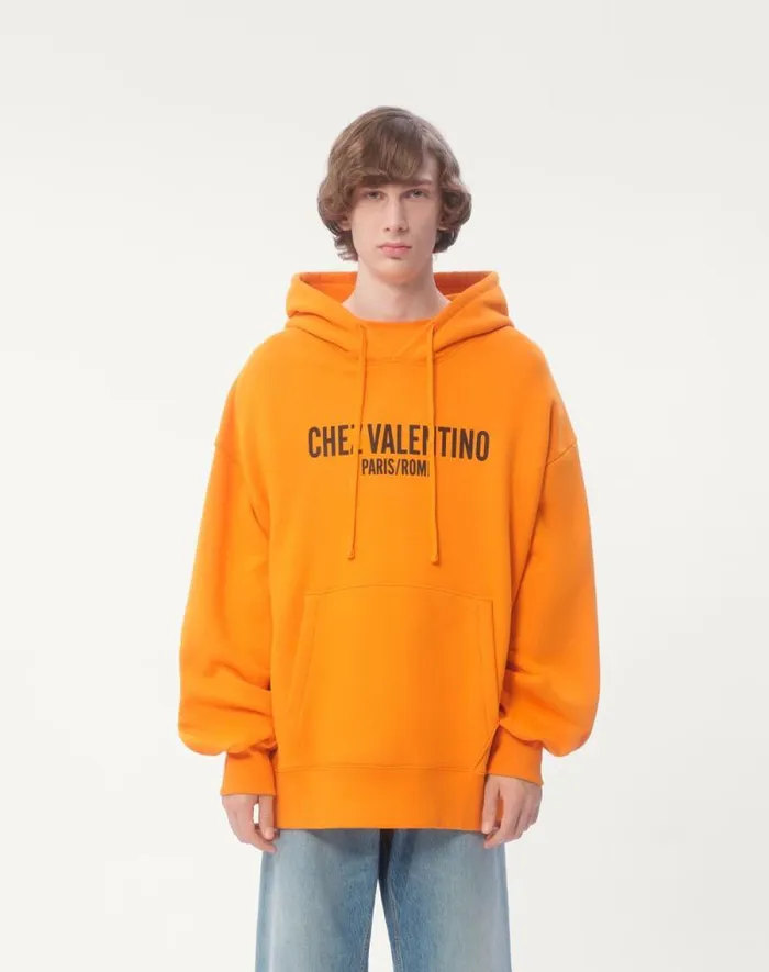 Valentino Tshirts And Sweatshirts Man Cotton Hooded Sweatshirt With Chez Valentino Print For Man In Orange Orange Valentino Tshirts And Sweatshirts Man Cotton Hooded Sweatshirt With Chez Valentino Print For Man In Orange Orange